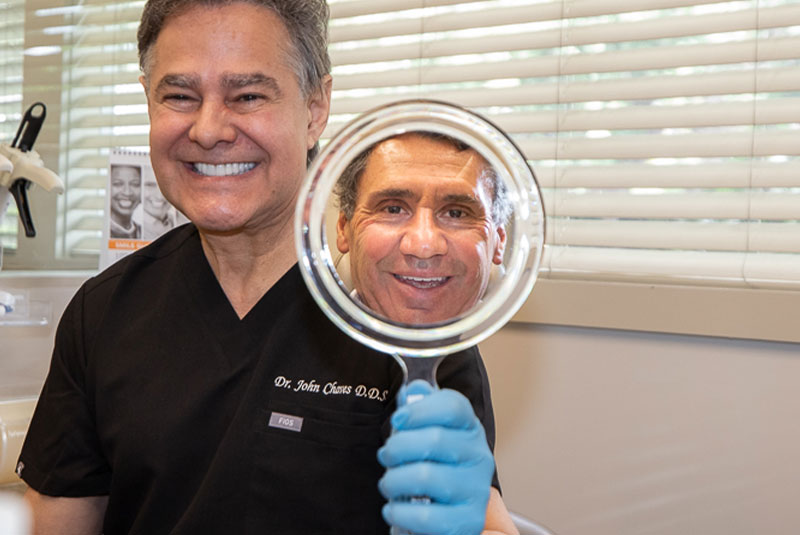 John M. Chaves, DDS showing patient their new smile