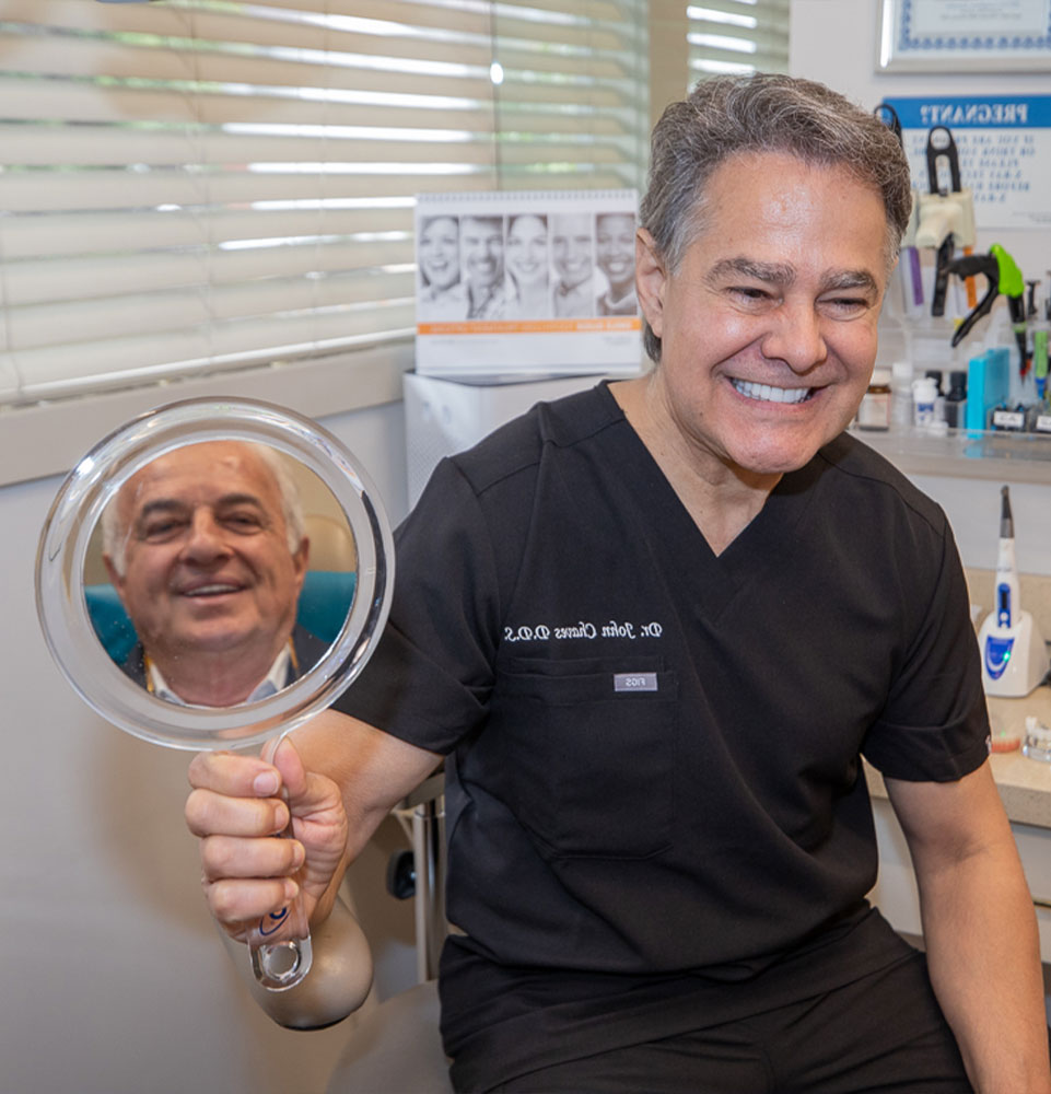 Patient smiling in the mirror with doctor within the dental practice
