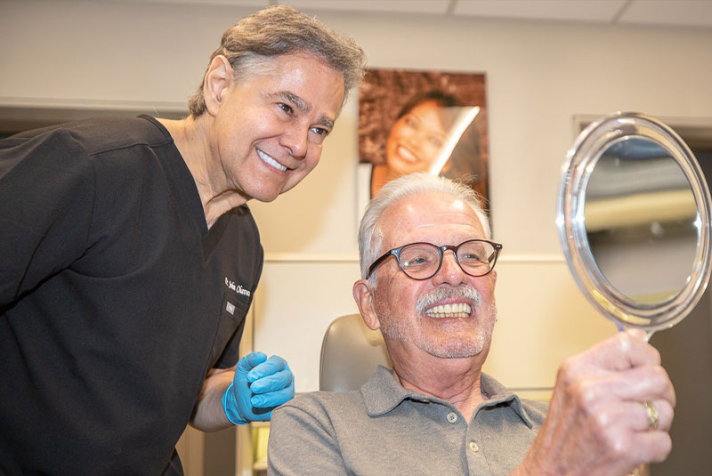 patient smiling confidently while looking in the mirror within the dental practice