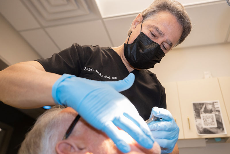 doctor helping patient with dental procedure within the dental practice