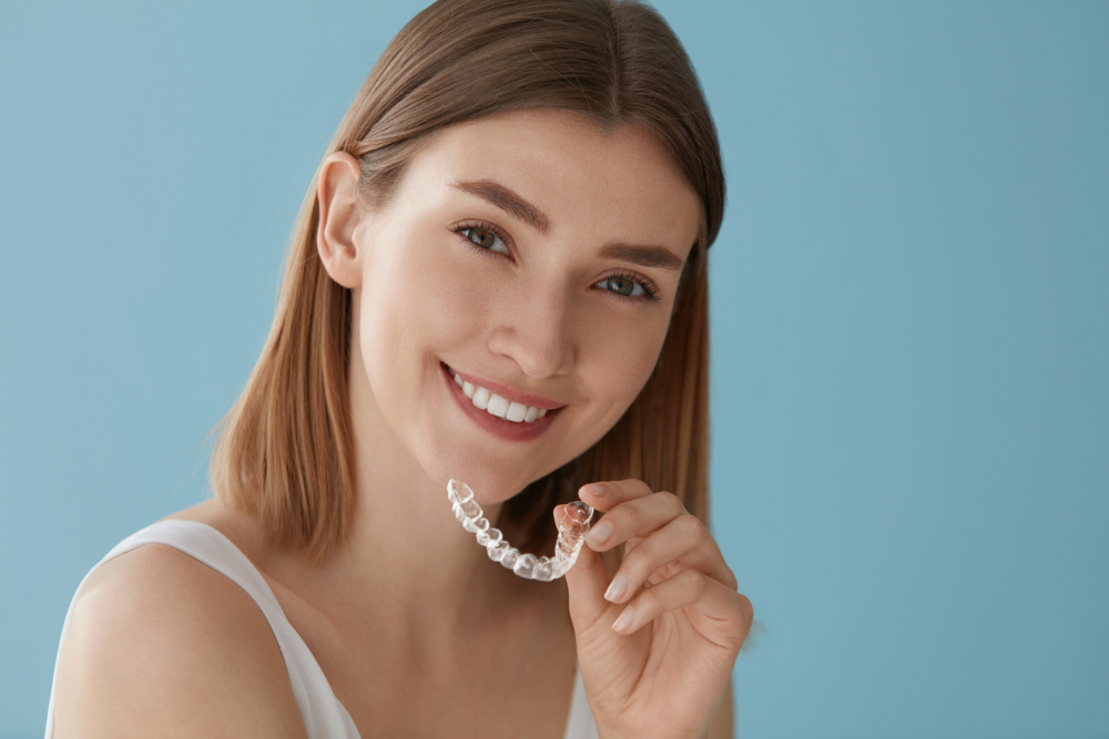 woman holding her Invisalign tray
