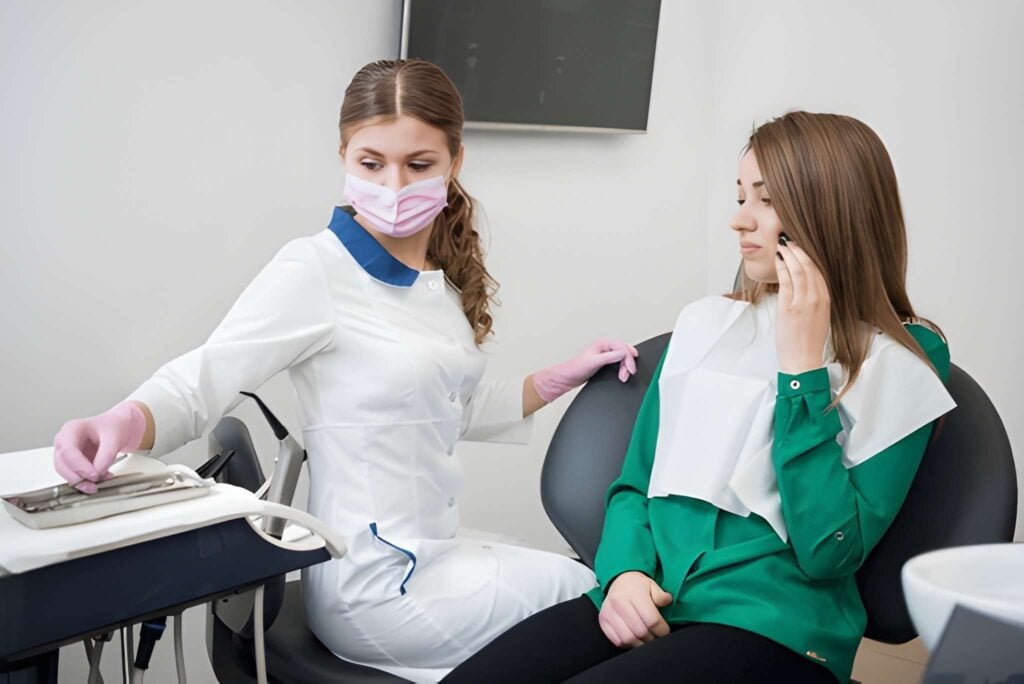 Dental assistant and patient in dental chair experiencing tooth pain, emergency dentistry in Woodland Hills,