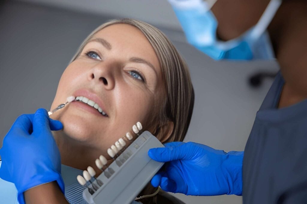 Woman receiving porcelain veneer color matching from dentist in Woodland Hills, California.