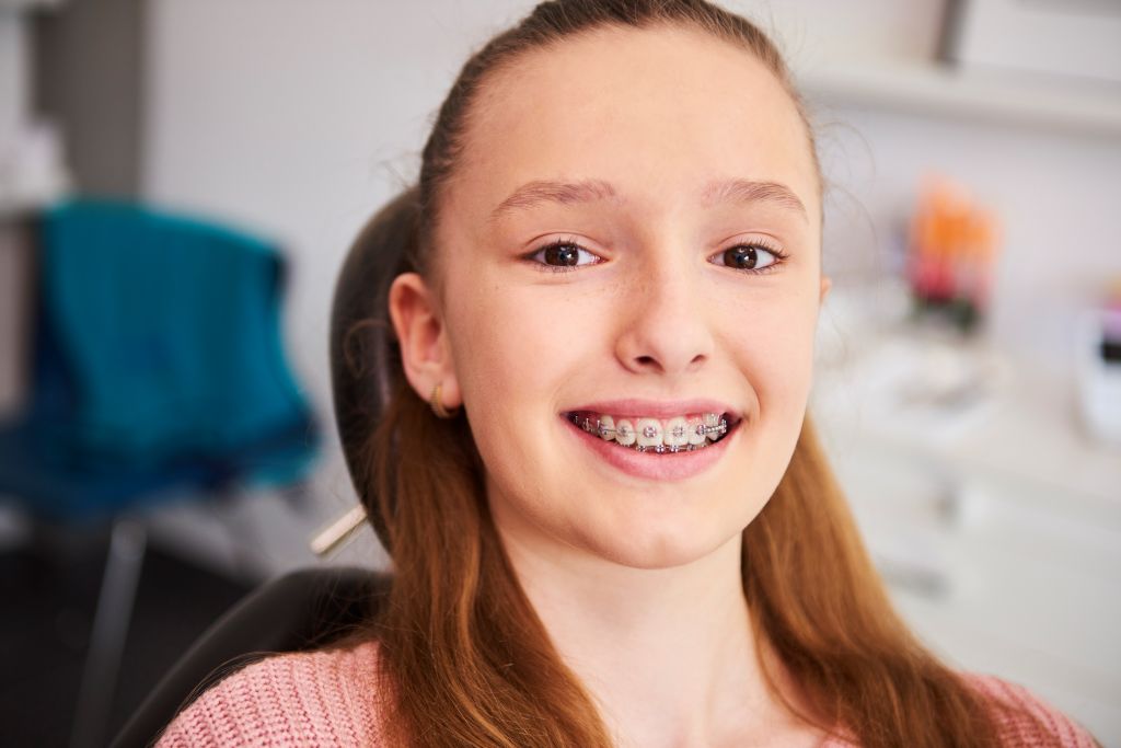 Young girl smiling with dental braces, showcasing personalized dental care near Hidden Hills, CA.
